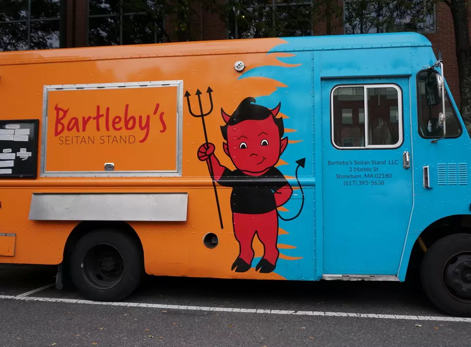 The big blue and orange Bartleby's food truck on the street.