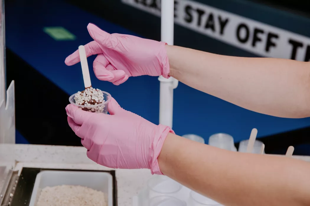 Staff member making and handing out banana pops at a corporate event