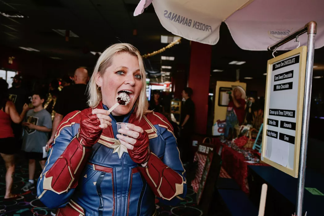 Photo of customer eating our banana pop dessert at comic con birthday event we catered to.